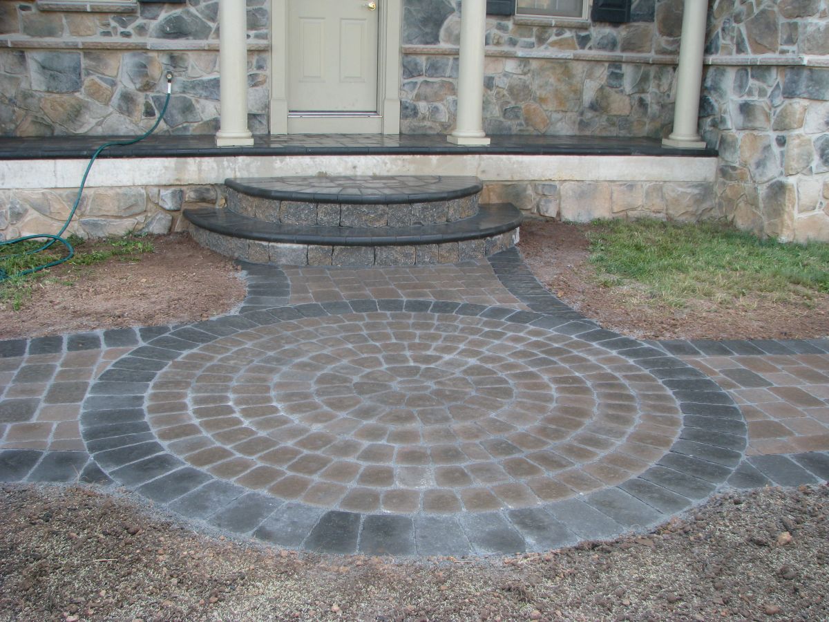 Stone patio with circular pattern and steps.