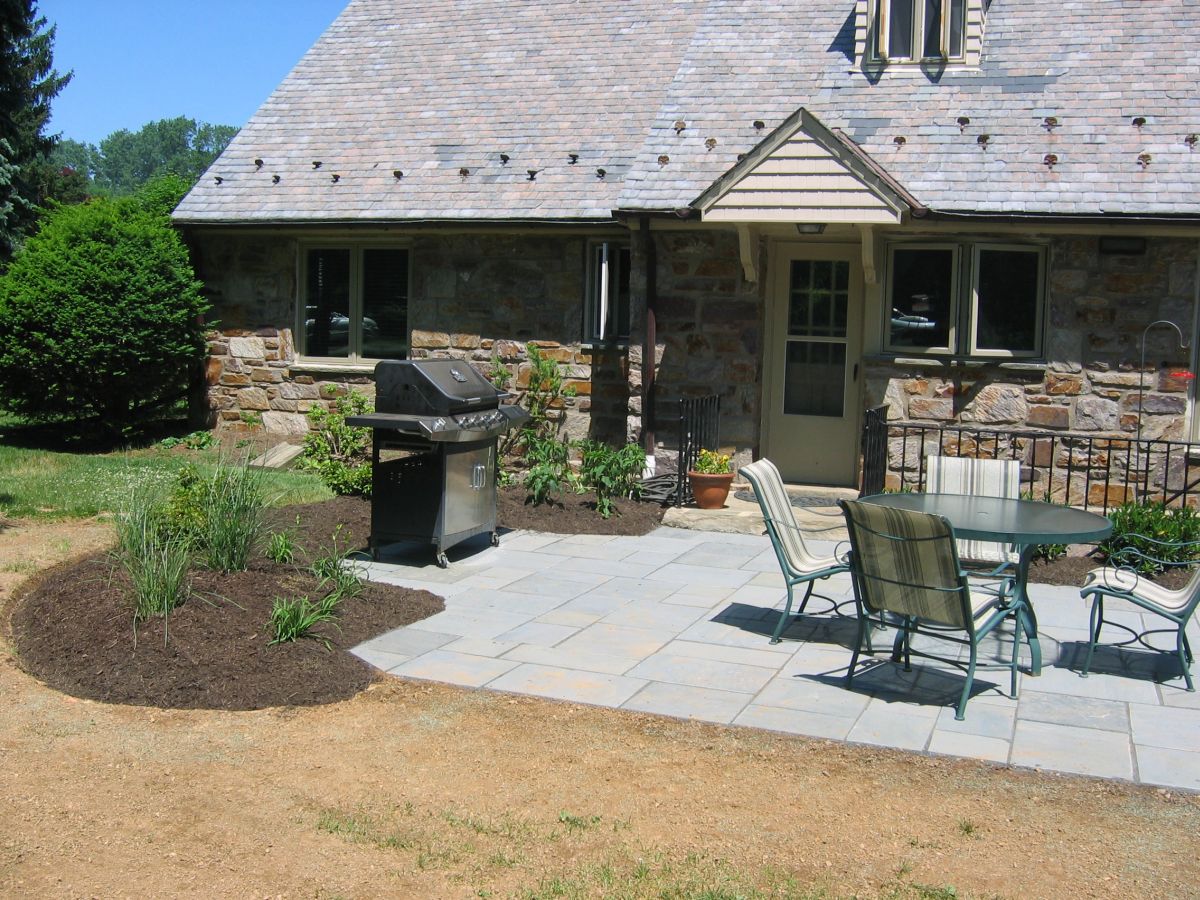 Small House With Brick Chimney. View of Backyard Walkout Deck With Patio Table Set