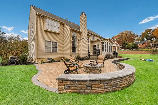 Backyard patio with fire pit and chairs.